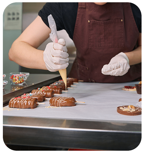 Pâtissier dressant des chocolats fins à la main